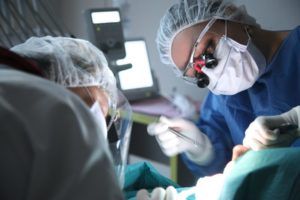 Dentist and assistant performing dental surgery on a patient
